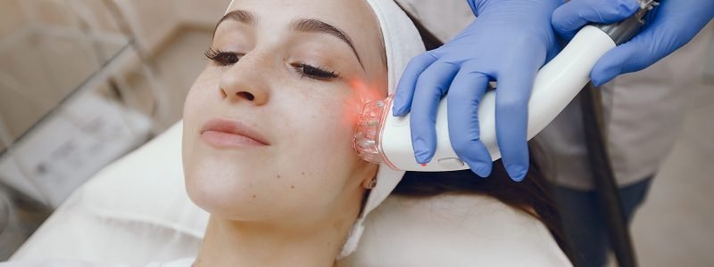 Cosmetologist use laser. Woman with cosmetologist. Lady in a beauty studio.